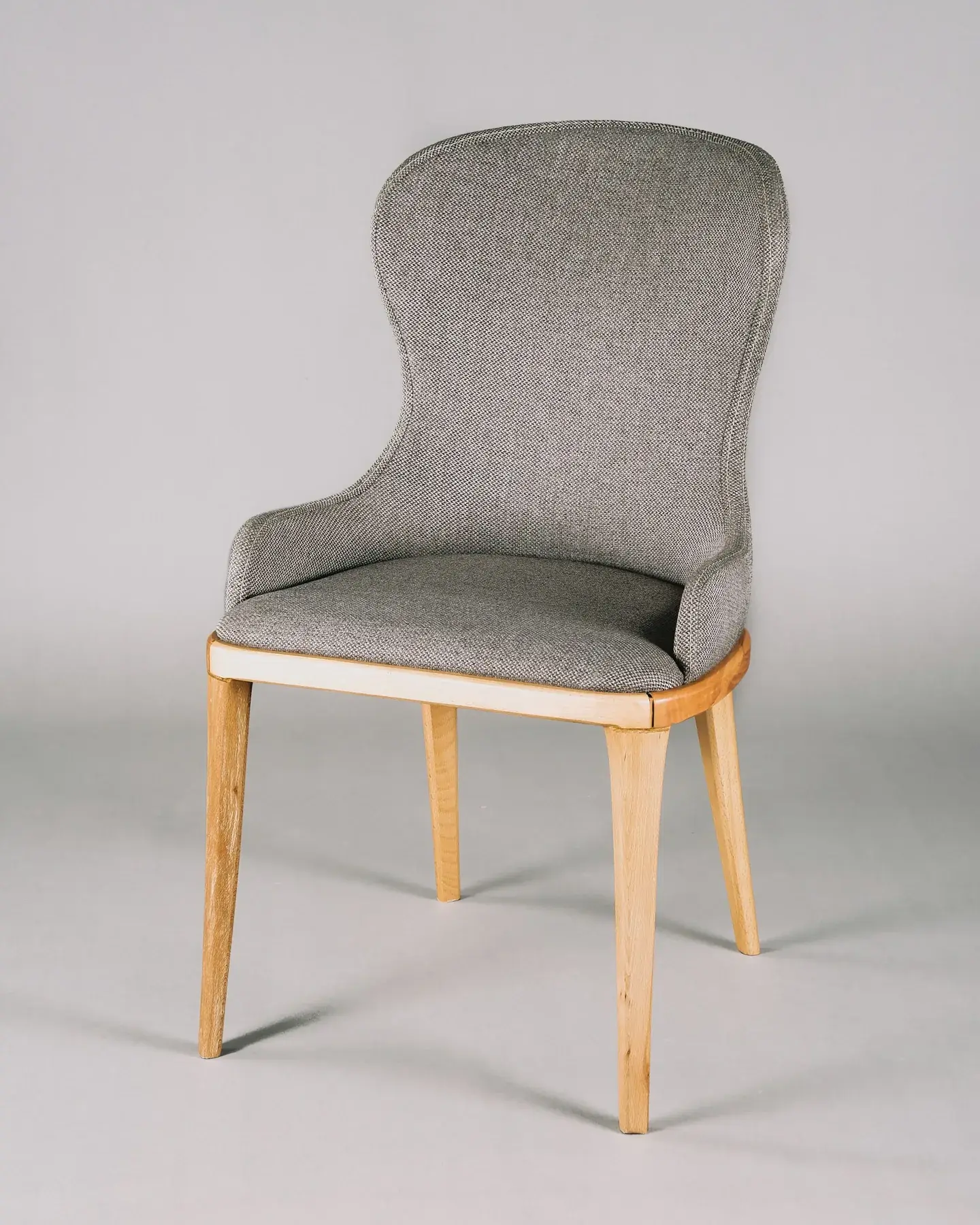 Grey upholstered dining chair with wooden legs